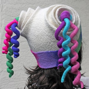 Puede incluir: Sombrero de fieltro blanco con un dise&ntilde;o escult&oacute;rico &uacute;nico. El sombrero presenta una serie de tiras de fieltro rizadas en rosa, verde, azul y morado.