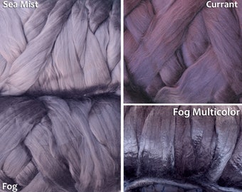 May include: Close-up of four skeins of hand-dyed yarn in shades of purple, gray, and black. The skeins are labeled "Sea Mist", "Currant", "Fog", and "Fog Multicolor".