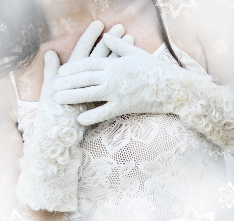 Puede incluir: Un par de guantes blancos y esponjosos con un dise&ntilde;o texturizado. Los guantes est&aacute;n siendo usados por una persona y se mantienen cerca de su pecho.