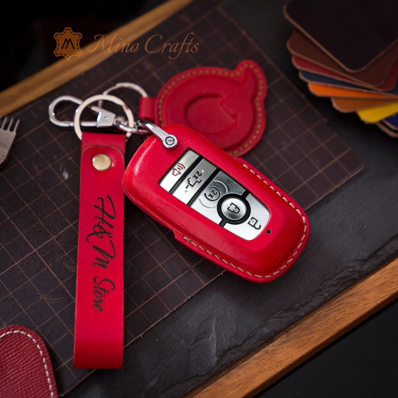 May include: Red leather key fob with a silver key and a red leather strap with the text "H&M Store" engraved on it.