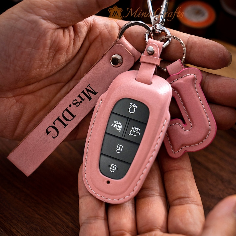 May include: Pink leather key fob with a key chain and a leather strap that says "Mrs. D.I.C."