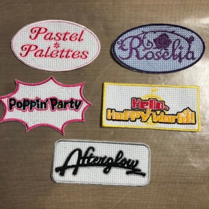 May include: Five embroidered patches with different designs and colours. The patches include "Pastel Palettes", "Rosebud", "Poppin' Party", "Hello Happy World", and "Afterglow".