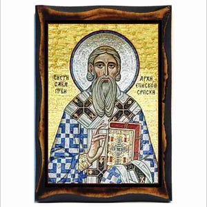 May include: A religious icon of Saint Sava, the first Archbishop of the Serbian Orthodox Church. The icon is painted in a mosaic style with gold, blue, and white colors. The icon depicts Saint Sava holding a book and wearing a bishop's robe. The text on the icon reads "Sveti Sava Prvi Arh Episkop Srpski".