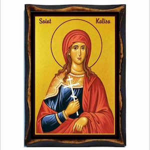 Può includere: Icona religiosa incorniciata raffigurante Santa Kalisa. L'opera raffigura una donna con un'aureola, che indossa un copricapo e una veste rossa, che tiene una croce bianca. Lo sfondo è dorato e la cornice è marrone scuro.