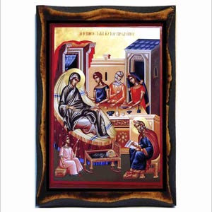 Op de afbeelding: Een ingelijst icoon dat de geboorte van Jezus voorstelt. Het icoon toont Maria die in bed ligt met de baby Jezus in een kribbe. Jozef zit rechts en schrijft in een boek. Drie vrouwen staan op de achtergrond, een houdt een kom vast. Het icoon is geschilderd in traditionele Byzantijnse stijl met levendige kleuren.