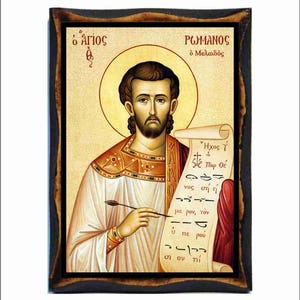 May include: A rectangular wooden icon featuring a Byzantine-style painting of Saint Romanos the Melodist. The figure holds a quill and a scroll with Greek text and musical notation. The icon has a dark, distressed border and a gold-toned background.
