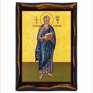 Puede incluir: Un icono religioso de San Mateo, el apóstol y evangelista, representado en un estilo bizantino tradicional. Él está sosteniendo un libro en su mano izquierda y tiene un halo alrededor de su cabeza. El icono está pintado en un panel de madera con un fondo dorado y un marco marrón oscuro.