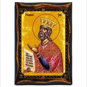 May include: A religious icon of the Prophet Job, painted in a traditional style. The icon features a bearded man wearing a crown and a red and gold robe, holding a scroll with Cyrillic text. The icon is framed in a dark wood frame with gold accents.