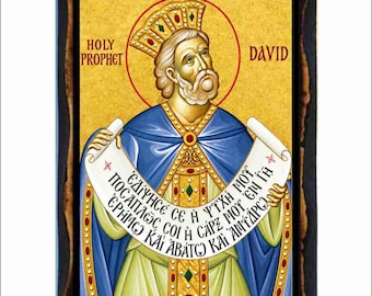 May include: A rectangular wooden plaque featuring a religious icon of Holy Prophet David. The figure wears a crown and blue robes, holding a scroll with Greek text. The background is gold, and the plaque has a dark, textured wooden border.