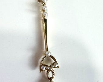 May include: A gold necklace with a pendant featuring a blue gemstone and pearl accents.