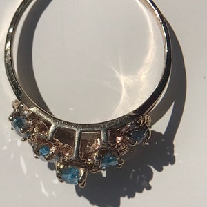May include: A silver ring with a cluster of blue gemstones set in a delicate design.