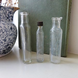 Antique trio of small clear glass vials, perfume with Bakelite lid, Phosferine quack cure, early 20th century bottles, bud vases Shelf decor