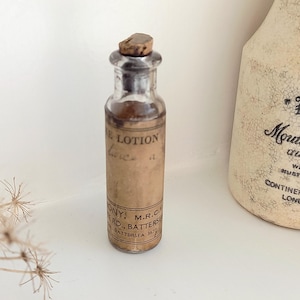 Antieke veterinaire fles, kleine injectieflacon, origineel papieren label The Lotion, tweemaal per dag aanbrengen, J. O'Mahony, 111 Northcote Rd, Battersea, met kurk