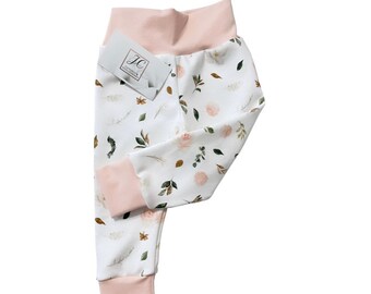 May include: White baby leggings with a pink waistband and cuffs. The leggings have a floral print with pink, green, and brown flowers and leaves.