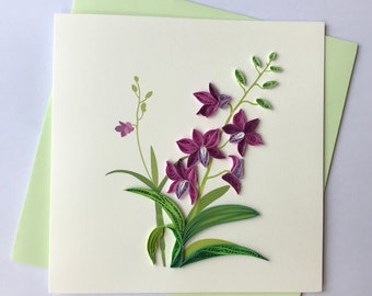 May include: A handmade greeting card featuring a purple orchid with green leaves and stems. The card is on a light green background.