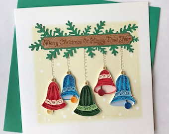 May include: A handmade Christmas card featuring a festive design of paper quilled bells hanging from a green garland with the text "Merry Christmas & Happy New Year".
