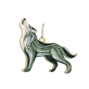 May include: A green and white paper quilled wolf ornament. The wolf is howling and has a string for hanging.