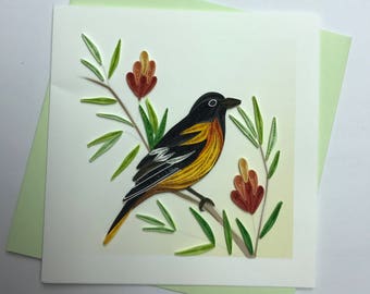 May include: A paper quilling card featuring a black, orange, and yellow bird perched on a branch with green leaves and red flowers.