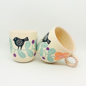 花のモチーフと黒い鳥が手描きされた手作りの陶器のマグカップ、陶器と陶器、手作りのカップ、コーヒーや紅茶愛好家への贈り物