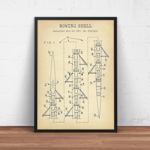 Może przedstawiać: Czarno-biały rysunek patentowy łodzi wioślarskiej. Patent nosi tytuł "ROWING SHELL" i został opatentowany 26 listopada 1991 roku. Numer patentu to 5067426. Rysunek przedstawia widok z boku łodzi wioślarskiej z wiosłami na miejscu.