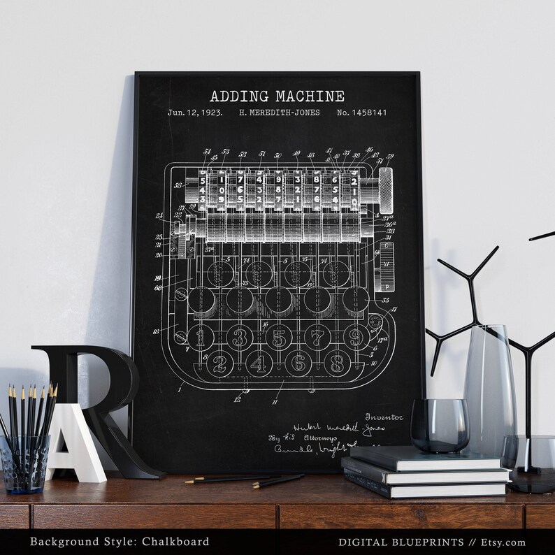 May include: Black and white vintage patent drawing of an adding machine on a chalkboard background. The patent drawing shows the machine's internal workings and the keys. The patent is titled "Adding Machine" and is dated June 12, 1923. The inventor is listed as H. Meredith-Jones.