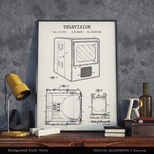 May include: A black and white vintage patent drawing of a television set. The drawing is framed and displayed on a wooden table with a yellow lamp and other decorative items. The patent is titled "TELEVISION" and is dated February 27, 1951. The patent number is 2,543,146.