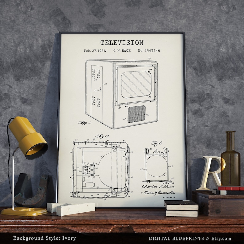 May include: A black and white vintage patent drawing of a television set. The drawing is framed and displayed on a wooden table with a yellow lamp and other decorative items. The patent is titled "TELEVISION" and is dated February 27, 1951. The patent number is 2,543,146.