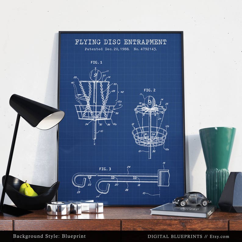 Może przedstawiać: Ilustracja w stylu planu technicznego patentu na urządzenie do chwytania latającego dysku. Patent został opatentowany 20 grudnia 1988 roku, a jego numer to 4792143. Ilustracja przedstawia trzy r&oacute;żne widoki urządzenia, kt&oacute;re jest rodzajem kosza do frisbee.