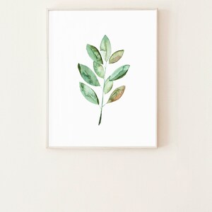 May include: A framed watercolor painting of a green leaf branch with a white background.