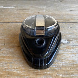 May include: Black inkwell with a clear plastic lid and a silver band. The lid has the word "Selectric" printed on it.
