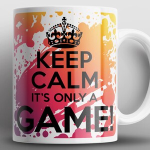 May include: White ceramic mug with a colorful abstract background. The mug features a black crown and the text "Keep Calm It's Only A Game!"