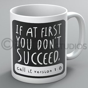 May include: White ceramic mug with a black square design. The text on the mug reads "If at first you don't succeed, call it version 1.0".