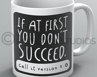 May include: White ceramic mug with a black square design. The text on the mug reads "If at first you don't succeed, call it version 1.0".