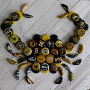 Arte mural con forma de cangrejo azul y tapa de botella de cerveza artesanal en amarillo y negro de los Pittsburgh Steelers