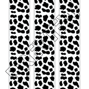 May include: Three vertical strips of black and white animal print fabric. The print resembles a cowhide pattern.