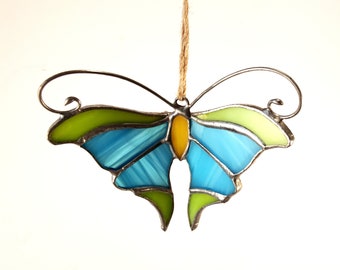 A small blue-green butterfly. Stained glass.