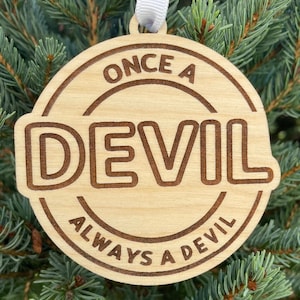 May include: A wooden Christmas ornament with the text "Once a Devil Always a Devil" engraved on it.