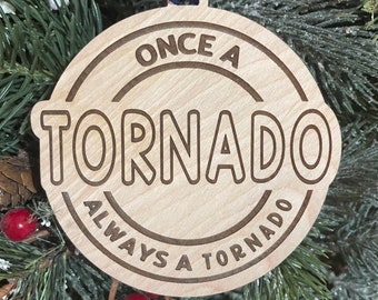 May include: A wooden Christmas ornament with the text "Once a Tornado Always a Tornado" in a circular design.