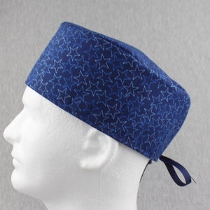 May include: A blue scrub hat with a white star pattern. The hat has a tie at the back.