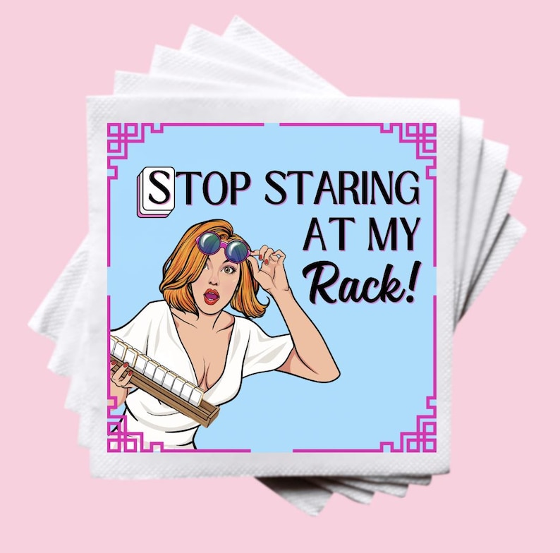 Op de afbeelding: Een stapel witte servetten met een afbeelding in pop-artstijl. De afbeelding toont een vrouw met rood haar en een zonnebril, die een rek met tegels vasthoudt. De tekst luidt "STOP STARING AT MY Rack!" in zwart en wit.