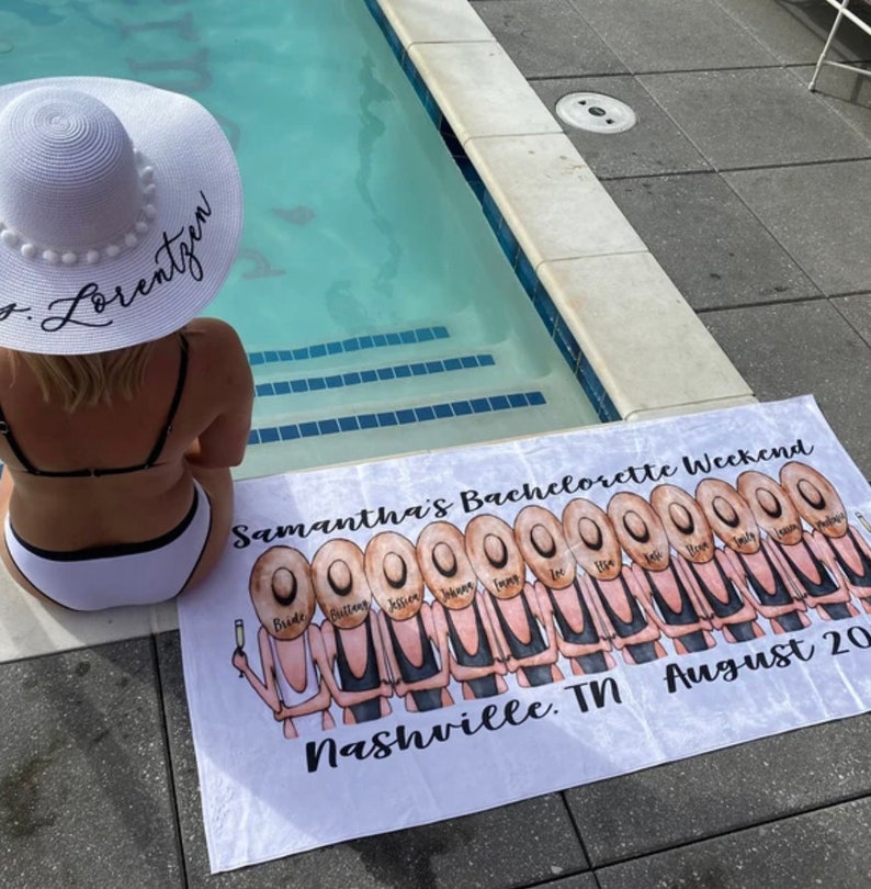 May include: White beach towel with a bachelorette party theme. It features a group of women in black swimsuits and straw hats, with the text "Samantha's Bachelorette Weekend" and "Nashville, TN August 20".