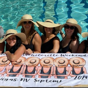 May include: A white beach towel with a bachelorette weekend theme. The towel features a group of women wearing black swimsuits and large straw hats. The text on the towel reads "Bachelorette Weekend", "Vegas, NV September 2021", and the names "Rachel", "Samantha", "Bridget", "Danielle", "Kimmy", and "Stephanie".