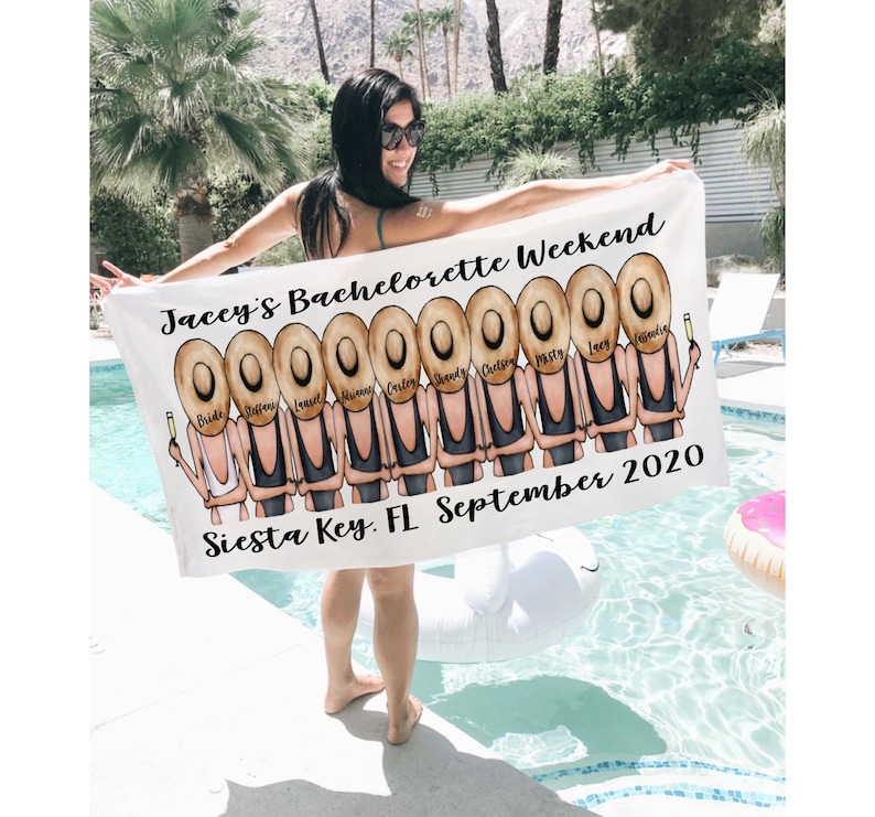 May include: White beach towel with a graphic of a group of women wearing black bathing suits and straw hats. The text "Jaccy's Bachelorette Weekend" and "Siesta Key, FL September 2020" is printed on the towel.