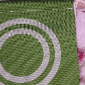 May include: Green fabric with two white concentric circles. The fabric has a textured woven pattern.