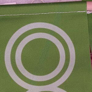 May include: Green fabric with a white double circle design. The fabric has a textured woven appearance.