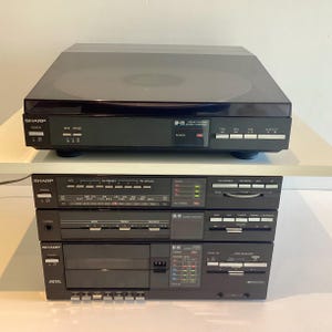 Puede incluir: Un juego de tres tazas de cerámica con un acabado moteado y mate. Las tazas son de color crema, gris claro y gris oscuro. Cada taza tiene un diseño simple y minimalista y un asa redondeada.