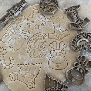 Puede incluir: Una colecci&oacute;n de cortadores de galletas en varias formas, incluyendo un reno, un &aacute;rbol de Navidad, un bast&oacute;n de caramelo, un cascanueces, un cerebro, un gnomo, un adorno navide&ntilde;o, un hacha vikinga y un hombre de jengibre. Los cortadores de galletas est&aacute;n hechos de metal y tienen un acabado plateado.