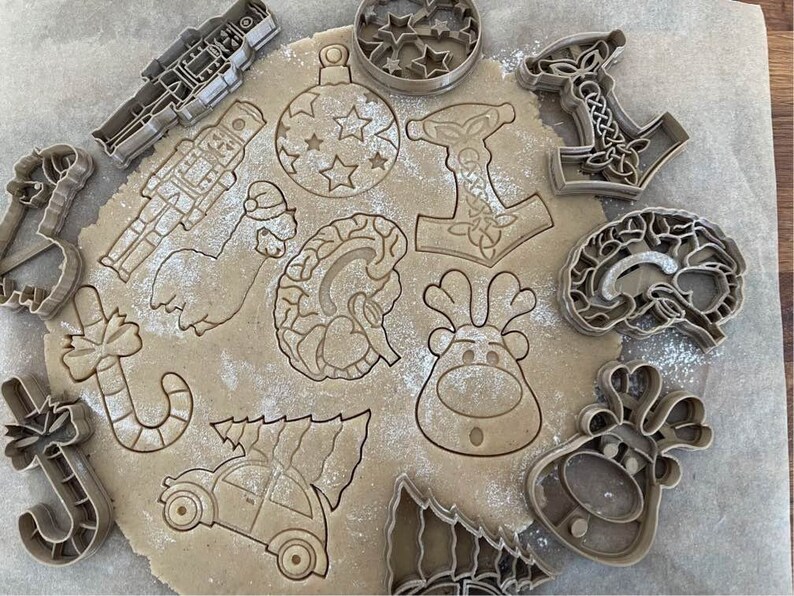 Puede incluir: Una colecci&oacute;n de cortadores de galletas en varias formas, incluyendo un reno, un &aacute;rbol de Navidad, un bast&oacute;n de caramelo, un cascanueces, un cerebro, un gnomo, un adorno navide&ntilde;o, un hacha vikinga y un hombre de jengibre. Los cortadores de galletas est&aacute;n hechos de metal y tienen un acabado plateado.