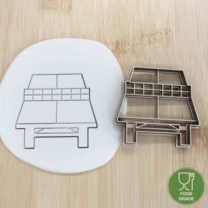 Könnte beinhalten: Ein Holz-Ausstecher in Form einer Picknick-Tabelle. Der Ausstecher ist lebensmittelecht und wird auf einer weißen Oberfläche gezeigt.