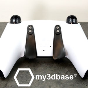 Può includere: Controller da gioco bianco con due attacchi a paletta neri e il testo "my3dbase®" sul fondo.